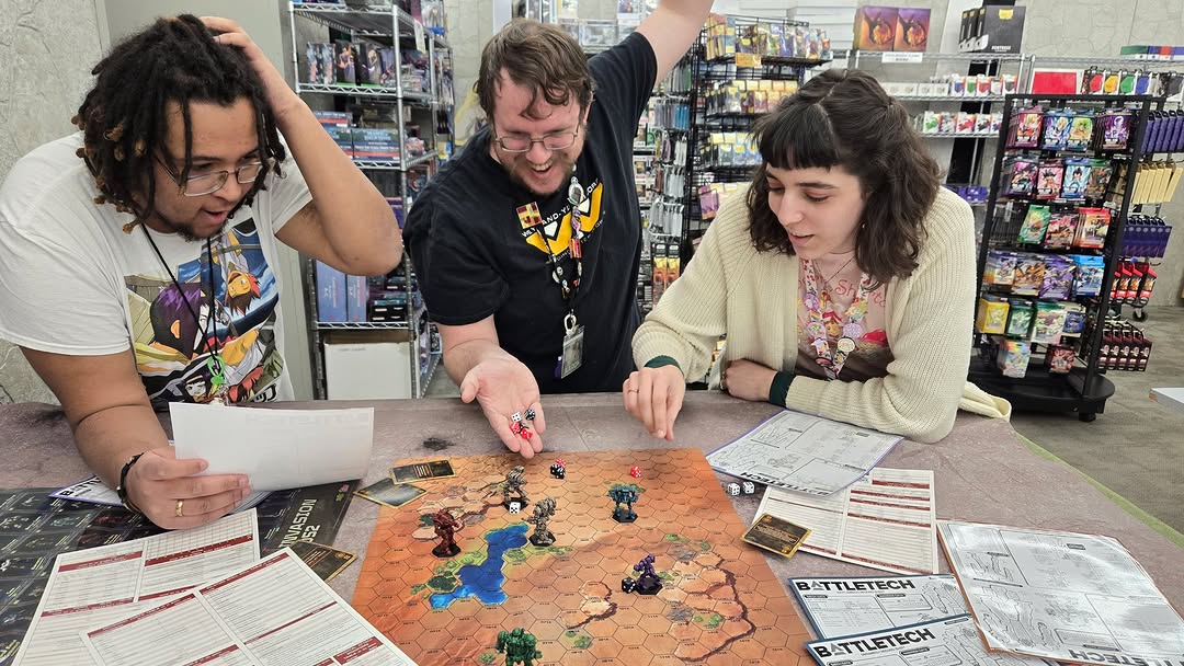 People playing a game of Battletech at a table